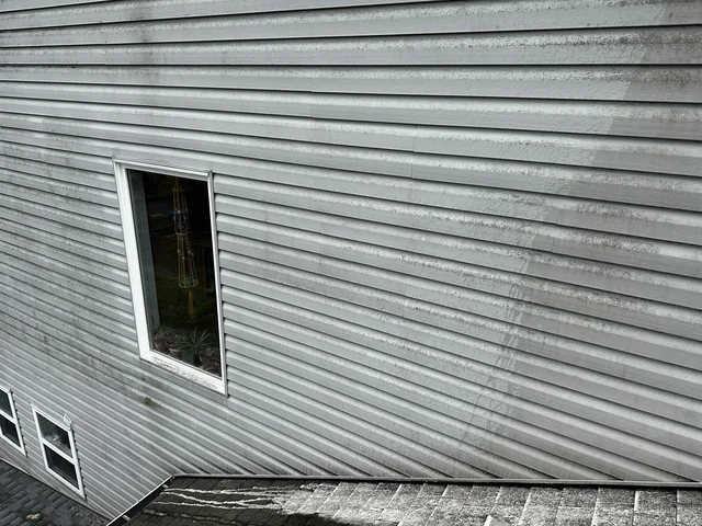 Close view of grey horizontal siding and a window